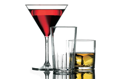 A full martini glass accompanied by an empty high ball tumbler with whiskey glass 
