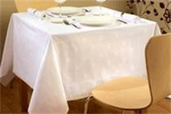 white patterned table linen on a set dinner table 
