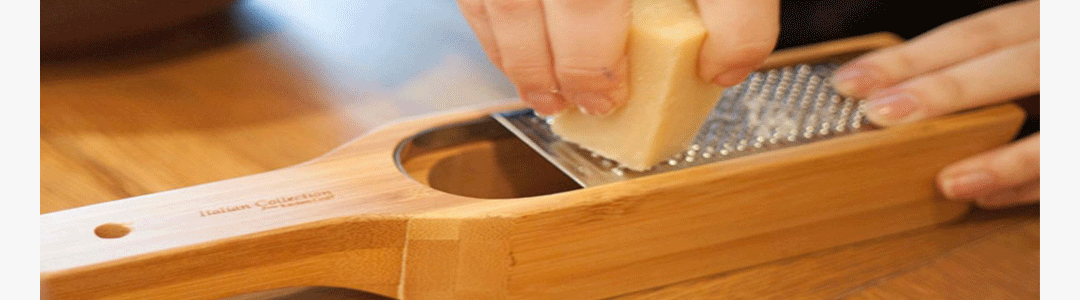 Cheese being grated over a cheese grater 