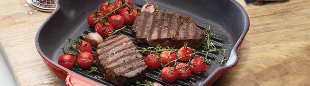 griddle pan with cooked steak and vine ripened baby tomatotoes